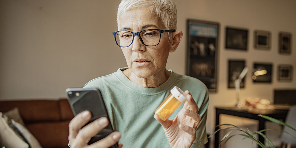 A woman holding a bottle of prescription medication