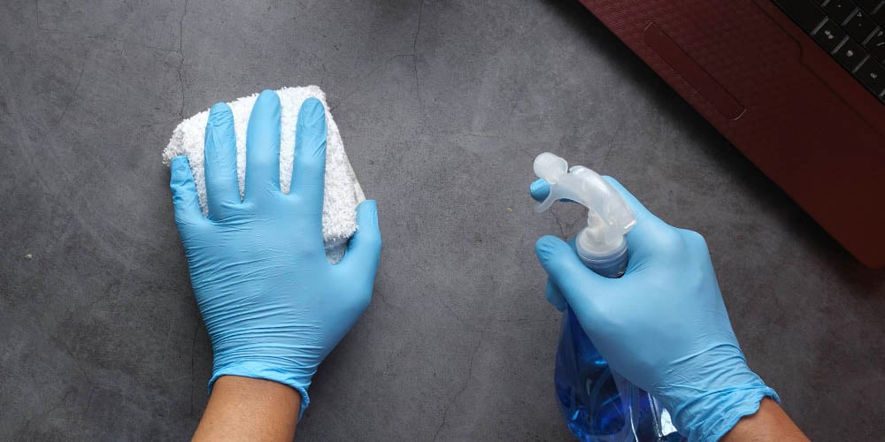 Hands disinfecting a surface