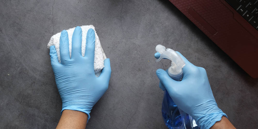 Hands disinfecting a surface